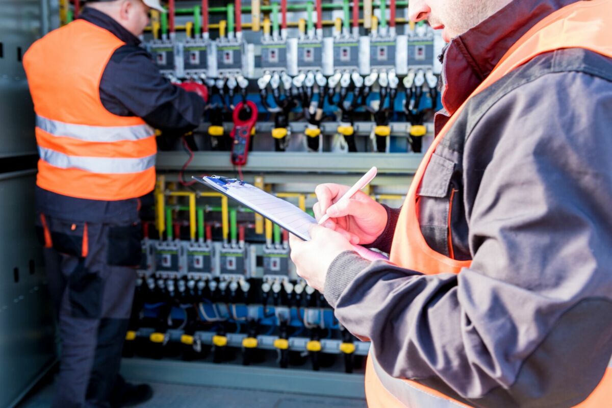 Zwei Elektriker bei einer Wartung am Schaltkasten